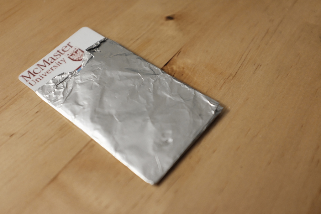 McMaster Student Identity Card with prototype RFID/GPS Protection case made of tin foil.