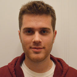 Image of SCDS Grad Resident Mark Belan. He is looking straight at the camera and standing in front of a white wall.