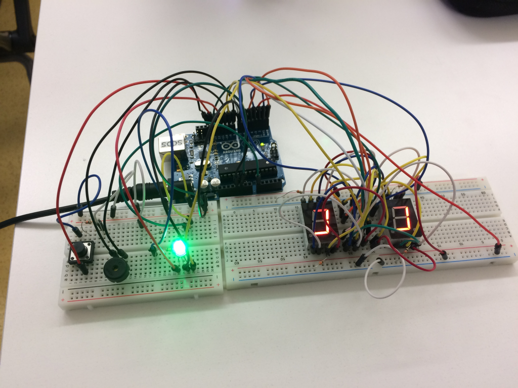A wired Arduino device with a green bulb.
